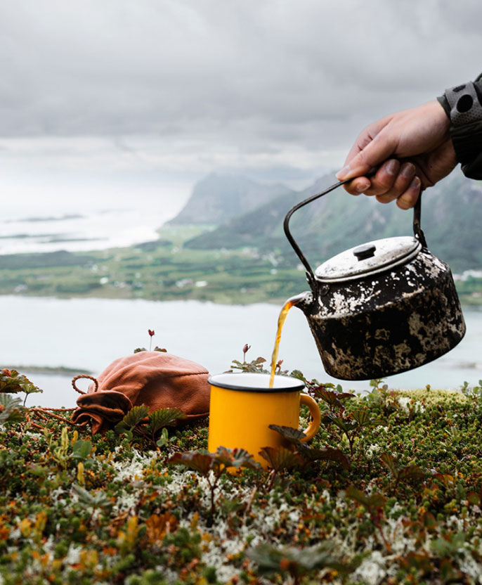 The founder of Rainydays, Ola Normann, on the top of a mountain, having a coffee outdoors.